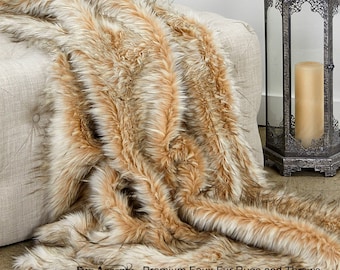 May include: A soft, plush faux fur throw blanket in shades of brown, beige, and white. The blanket is draped over a light-colored couch and has a long, flowing texture. The text "Fur Accents® Premium Faux Fur Rugs and Throws" is visible in the bottom right corner of the image.