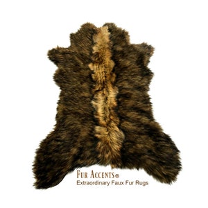May include: A brown and tan faux fur rug with a long, shaggy pile. The rug is shaped like a hide and has a natural, rustic look. The text "FUR ACCENTS® Extraordinary Faux Fur Rugs" is printed at the bottom of the rug.