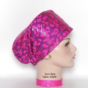 May include: A pink and purple leopard print Euro Style fabric surgical scrub cap. The cap is on a mannequin head with a matching pink choker. The text "Euro Style Fabric #S699" is visible.
