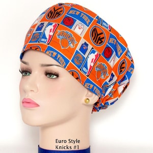 May include: An orange scrub cap featuring a repeating pattern of New York Knicks basketball logos, NBA emblems, and basketball graphics in blue, white, and orange. The cap has a rounded crown and a gathered back, with the text Euro Style Knicks #1.