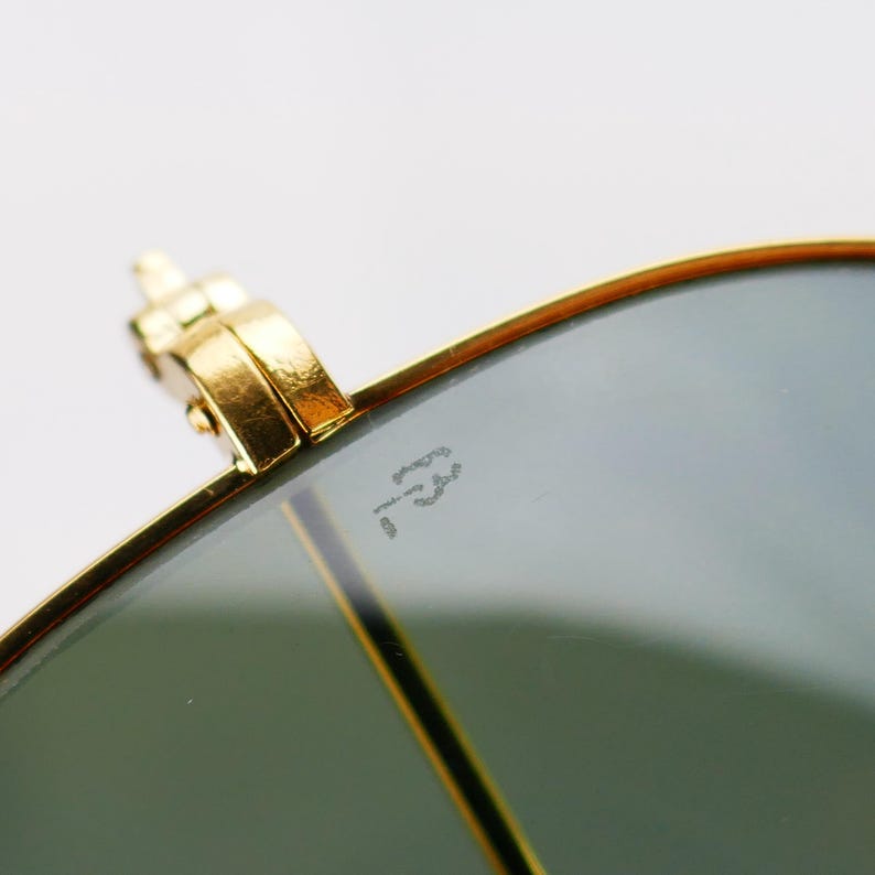 May include: A white ceramic mug with a black handle and the text "But First, Coffee" in a bold, black font. The mug is set against a blurred background, suggesting a cozy setting.