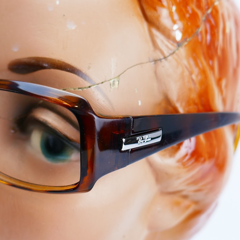 Peut inclure: Gros plan sur des lunettes Ray-Ban en &eacute;caille de tortue marron avec des accents argent&eacute;s. Les lunettes sont sur le visage d'un mannequin.