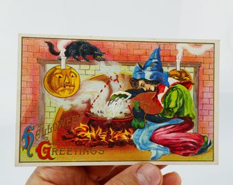 Könnte beinhalten: Vintage Halloween-Postkarte mit einer Hexe, die einen Kessel mit einer schwarzen Katze und einer Jack-o'-Laterne umrührt. Die Karte trägt die Aufschrift "Halloween Greetings" in einer dekorativen Schriftart. Die Farbpalette umfasst Orange, Rot, Grün und Blau.