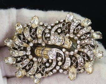 Broche Art Déco Coro Duette, bijuteria em tom prateado, com raros strass transparentes.