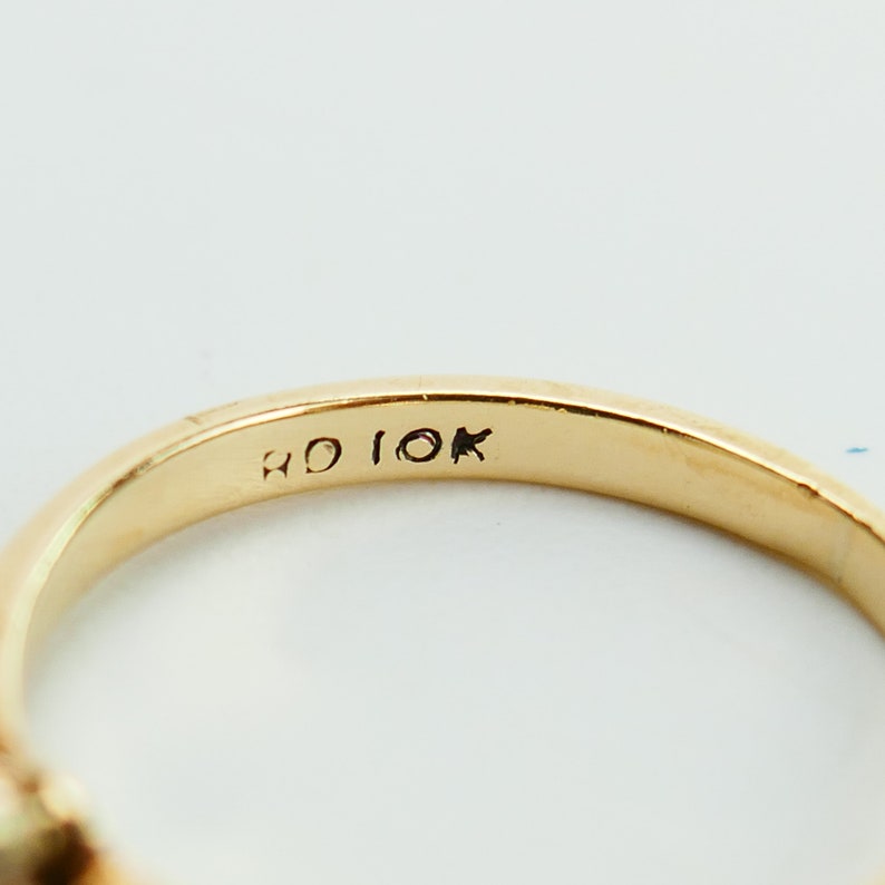 K&ouml;nnte beinhalten: Nahaufnahme des Inneren eines Goldrings mit der Inschrift "RD 10K" auf der Band.