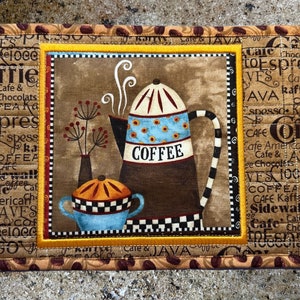 May include: A brown and tan quilted pot holder with a coffee pot and a sugar bowl design. The pot holder has a yellow border and the words "COFFEE" and "Cafe & JAVA" are printed on the border.