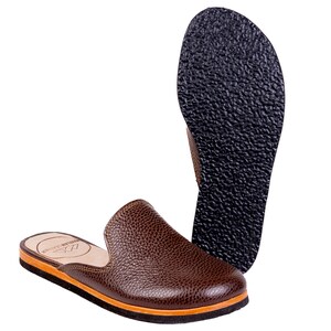 May include: Brown leather slip-on shoe with a textured upper and a contrasting orange and black sole. The shoe has a rounded toe and a low heel. The sole of the shoe is black and textured. The shoe is designed for comfort and style.