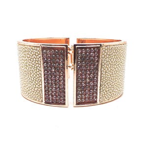 Peut inclure: Un bracelet jonc en or avec une surface texturée blanche et deux sections rectangulaires de strass transparents.