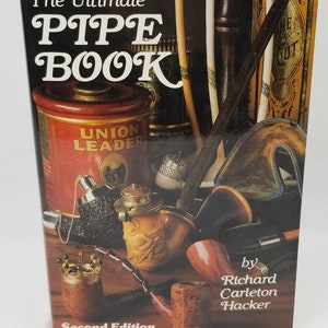 May include: The Ultimate Pipe Book, second edition, by Richard Carleton Hacker. The cover features a collection of pipes, tobacco tins, and other smoking accessories.