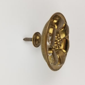 May include: Gold-toned metal flower-shaped knob with a screw for attaching to a surface.