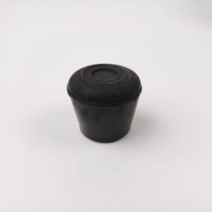 Può includere: Una tazza di ceramica bianca con manico nero e la scritta "But First, Coffee" in grassetto nero. La tazza è appoggiata su una superficie di legno. La tazza è alta circa 10 cm.