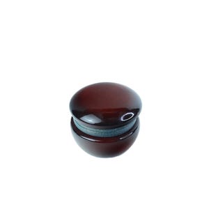 May include: A dark brown, glossy bottle stopper with a rounded top and a cylindrical base. The stopper has a metallic band around the middle. The product is set against a white background.