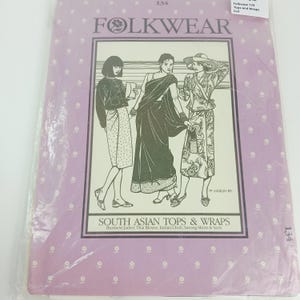 Peut inclure: Une pochette de patron Folkwear 134 pour des hauts et des enveloppes d'Asie du Sud, illustrant une veste birmane, un chemisier thaï, un choli indien, des jupes sarong et des saris. L'emballage est violet clair avec un motif floral blanc et du texte noir.