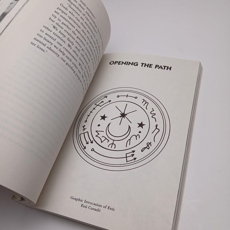 Puede incluir: Un libro abierto con p&aacute;ginas de color blanco roto, texto negro y un dise&ntilde;o gr&aacute;fico circular. El texto en la parte superior dice OPENING THE PATH, y el texto en la parte inferior dice Graphic Invocation of Ex&uacute;: Ex&uacute; Curad&oacute;. El gr&aacute;fico es un c&iacute;rculo.