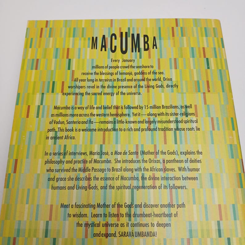 Puede incluir: Una portada de libro amarilla con un patr&oacute;n vertical de rect&aacute;ngulos de color verde claro, naranja y verde azulado. El t&iacute;tulo MACUMBA est&aacute; impreso en negro en la parte superior, seguido de varios p&aacute;rrafos de texto negro sobre tradiciones.