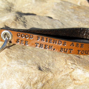 May include: Brown leather keychain with a silver key ring. The leather has the text "Good friends are like stars. You don't always see them, but you know they're always there." embossed on it.