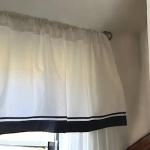 May include: White sheer curtains with a black and white trim. The curtains are hung on a metal rod.