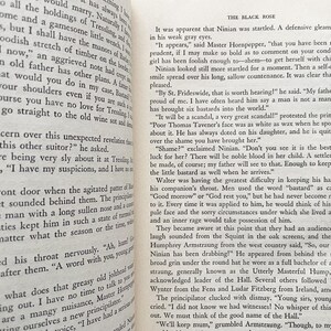 Puede incluir: Una imagen en blanco y negro de una p&aacute;gina de libro con texto de una novela. El texto trata sobre un hombre llamado Ninian que ha tenido un hijo fuera del matrimonio. El texto habla del esc&aacute;ndalo y la verg&uuml;enza que esto traer&aacute; a su familia. El texto tambi&eacute;n menciona la reacci&oacute;n del padre del hombre a la noticia.