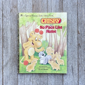 May include: A vintage Little Golden Book titled "Crispy in No Place Like Home". The cover features a cartoon lion with a red ball and other animals in a forest setting. The book is a special edition and includes a free offer for Post Crispy Critters cereal.