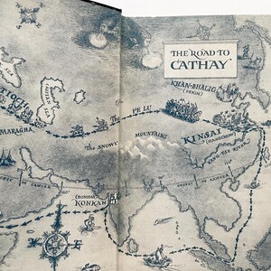 Puede incluir: Un mapa vintage que representa la Ruta de la Seda, una ruta comercial hist&oacute;rica que conectaba Oriente y Occidente. El mapa muestra la ruta desde Antioqu&iacute;a hasta Kinsai (Hangchow) en China, con lugares clave y caracter&iacute;sticas geogr&aacute;ficas etiquetados. El mapa est&aacute; impreso en papel de color crema con un aspecto descolorido y antiguo.