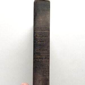 Puede incluir: Un libro negro con letras doradas en el lomo. El t&iacute;tulo es "The Dark Room" de "Costain".