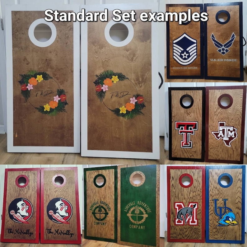 May include: A collection of wooden cornhole board sets featuring various designs, including floral wreaths, military emblems, university logos, and custom text. Each board has a circular hole at the top and is framed with painted borders.