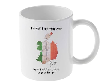 May include: White ceramic mug with a green, white, and orange map of Ireland. The text on the mug reads "I googled my symptoms. Turned out I just need to go to Ireland."