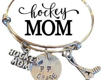 May include: Silver charm bracelet with a hockey stick charm, a charm that says "Hockey Mom", and a charm with the text "#7 CHASE".