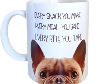 May include: White ceramic mug with a brown French Bulldog design. The mug has the text "EVERY SNACK YOU MAKE, EVERY MEAL YOU BAKE, EVERY BITE YOU TAKE" in black. The mug has a white handle, perfect for tea or coffee.