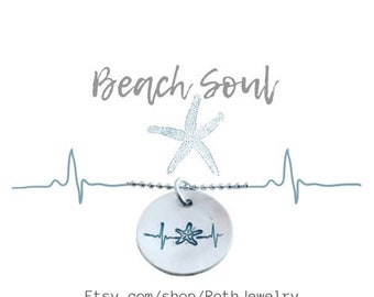 May include: A silver-colored necklace with a round pendant featuring a starfish and heartbeat design. The words "Beach Soul" are above the necklace, and the Etsy shop URL is at the bottom.