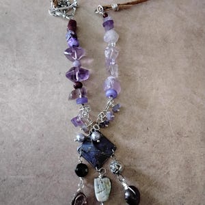 May include: A white ceramic mug with a black handle and the text "But First, Coffee" in a black, bold font. The mug is on a white surface.