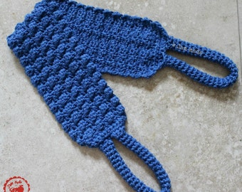 May include: A blue crocheted scrubbie with two loops. The scrubbie has a textured surface and is made with a thick yarn.