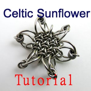 May include: A silver Celtic Sunflower jewelry piece, made with wire, in the shape of a flower with eight points. The center of the flower is a woven design. The piece is on a white background.