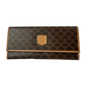 May include: A rectangular brown wallet featuring a dark brown repeating logo pattern across the surface. The wallet has light tan leather trim along the edges and a centred, embossed light tan leather patch displaying the Celine logo and text.