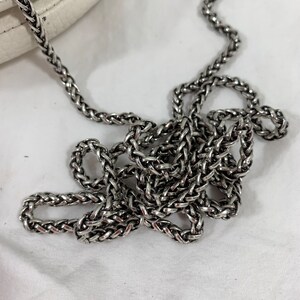 May include: A silver chain strap for a handbag. The chain is made of interwoven links and has a polished finish.