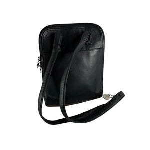 May include: Black leather backpack with adjustable straps and a top zipper closure. The bag has a rectangular shape with rounded corners and a small silver-toned charm attached to the strap.