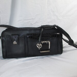 May include: Black leather handbag with a braided strap and a silver heart-shaped buckle.