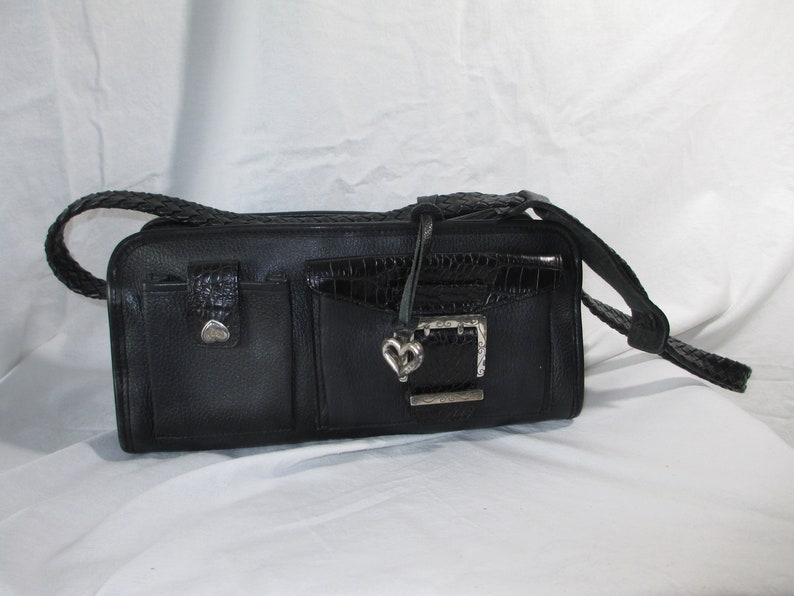 May include: Black leather handbag with a braided strap and a silver heart-shaped buckle.