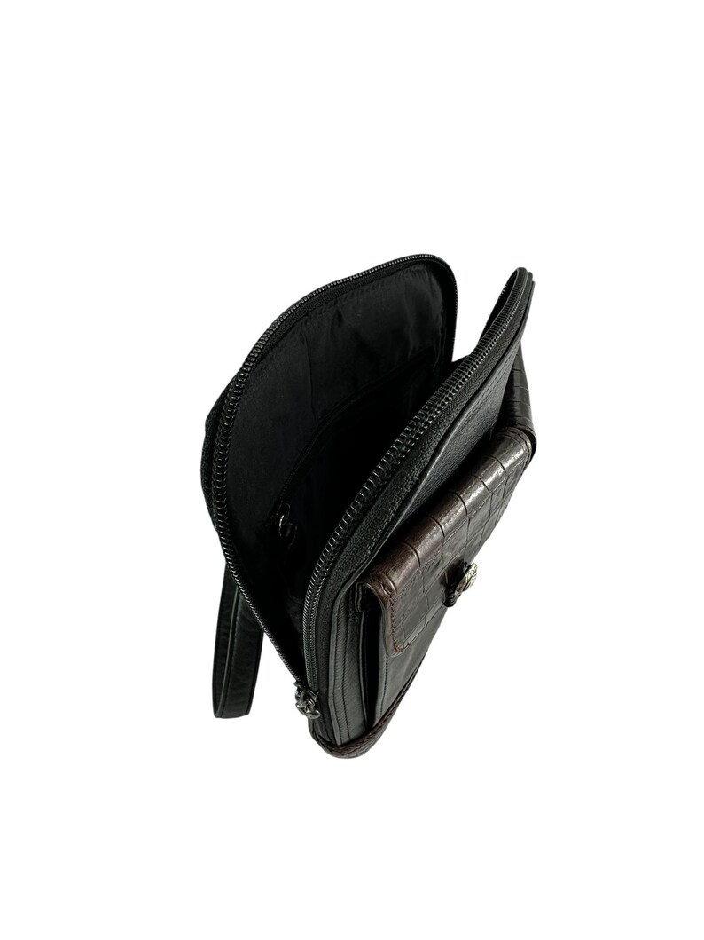 May include: Black leather clutch with a brown crocodile-textured pocket. The clutch is open, revealing a black interior. A silver-toned clasp secures the pocket. The zipper is black.