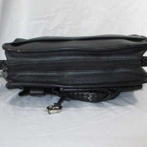 May include: Black leather handbag with a braided strap and a heart-shaped charm.