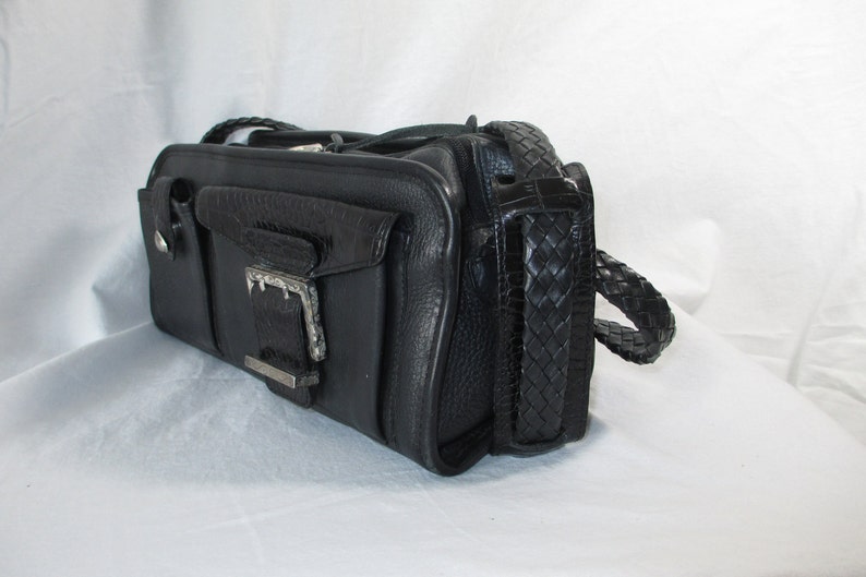 May include: A black leather handbag with a braided strap and a silver buckle.