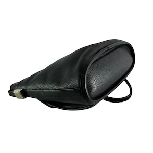 May include: Black leather shoulder bag with a rounded shape. The bag features a textured surface and a single strap. A silver-colored metal clasp is visible on the side.