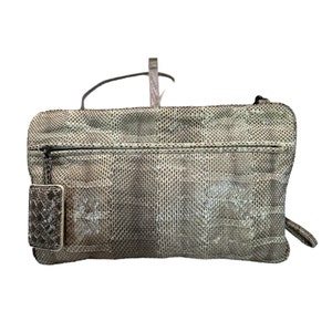May include: A gray snakeskin clutch bag with a zipper closure and a small matching pouch attached.