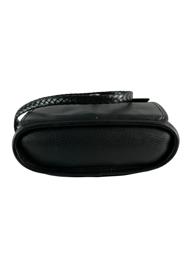 May include: Black leather crossbody bag with a braided strap. The bag has a rounded bottom and a textured surface. The strap is also black and braided. The bag is designed to be worn over the shoulder.