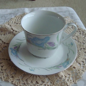 Tea or Coffee Cup & Saucer, White w/ Blue and Pink / Lavender Flowers on Green Vine with Leaves and Silver Rim, Ceramic, Collectible 1980s