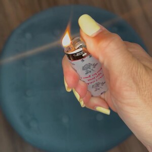 May include: A lit lighter with a floral design and the text "I want my soul faced with roses". The lighter has a gray background with roses and is held by a hand with yellow nail polish.