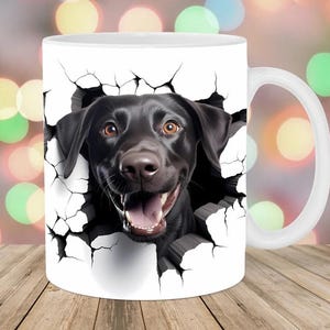May include: White ceramic mug featuring a black Labrador Retriever bursting through a cracked wall design. The dog has brown eyes and a happy expression. The mug has a white handle and is suitable for hot or cold beverages.