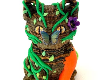 Forest Cat 3D printed Figure. Green leaves and vines with brown tree trunk body, orange leg and butterfly and flower.