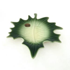May include: A green ceramic leaf-shaped dish with a white center and a gold label that reads "Vero-car Hand-made".