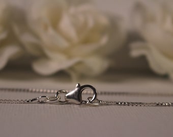 May include: A silver chain necklace with a lobster clasp closure.